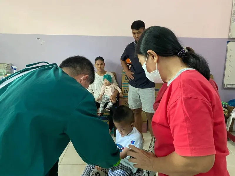 A doctor and a nurse attend to a small child during a medical visit.