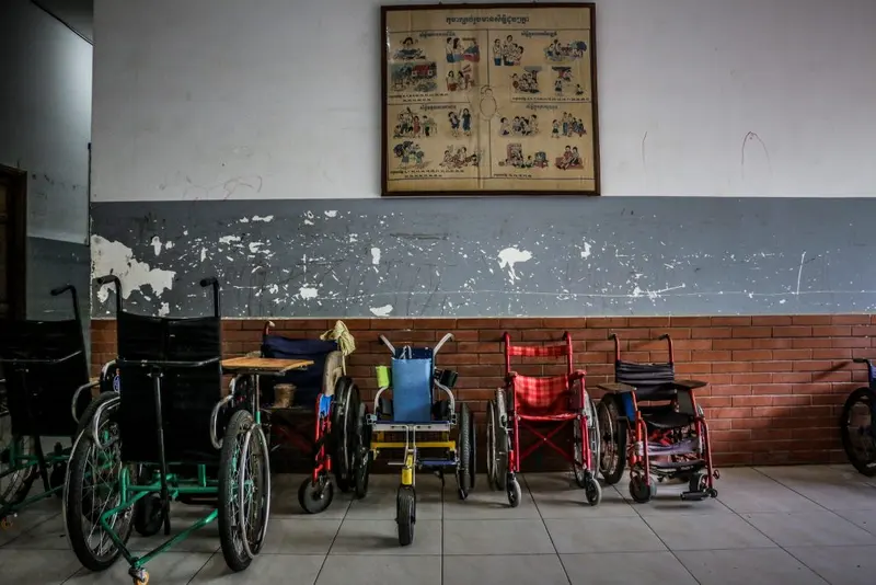 A row of wheelchairs lined up along a wall at the center.